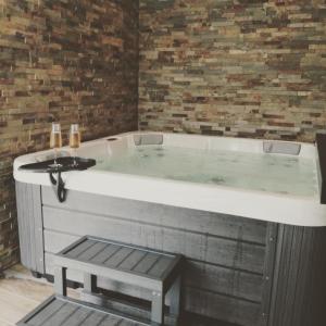 a large bath tub in a room at Où gît le Bocq Spa privatif in Ciney