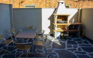 eine Terrasse mit einem Tisch, Stühlen und einem Kamin in der Unterkunft Apartamentos Rurales El Calama in Zarza de Granadilla