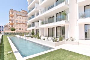 an exterior view of a building with a swimming pool at ECO-APARTMENTS LA MARINEDA in Roses