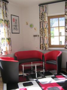 a living room with a red couch and a table at Haus Bellevue in Obertraun