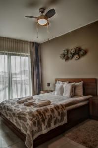 ウストカにあるDeluxe by Maximusのベッドルーム1室(大型ベッド1台、シーリングファン付)