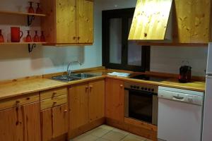 een keuken met houten kasten, een wastafel en een fornuis bij CASA GRAN MONSONIS in Montsonis
