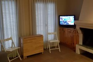 sala de estar con TV, 2 sillas y vestidor en CASA GRAN MONSONIS, en Montsonís