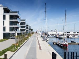 a marina with boats in the water and a building at Apartament Faltom Gdynia Yacht Park in Gdynia