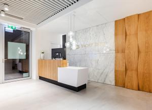 a lobby with a white counter and a wall at Apartament Faltom Gdynia Yacht Park in Gdynia