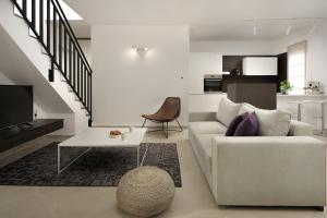 a living room with a white couch and a table at Sea View Villa Cala Royal in Krnica