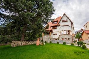 uma casa grande numa colina com um jardim verde em Moviliţa Residence em Sinaia