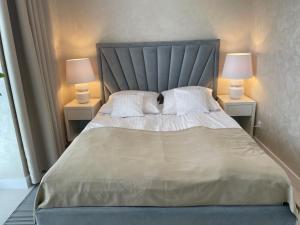 sypialnia z dużym łóżkiem i dwiema lampami w obiekcie Apartament Faltom 20 Yacht Park Premium w mieście Gdynia +37 zdjęć