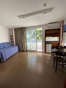 Hotel Apartamentos Solimar في كالافيل: غرفة نوم بسرير وطاولة وكراسي