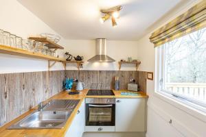 a kitchen with a sink and a stove at Heather Lodge 17 with Hot Tub in Belladrum
