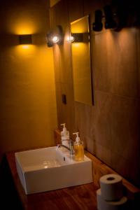y baño con lavabo blanco y espejo. en Shamba lodge cabins, en Arusha