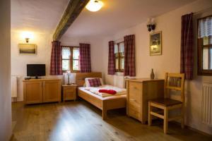 a bedroom with a bed and a desk and a tv at Penzion U Zlomené lyže in Železná Ruda