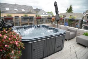 a hot tub on top of a deck at Race & Rooms Appartment in Stavelot