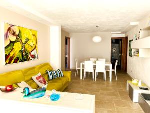 a living room with a yellow couch and a table at Charming Apartment in Nardò with Shared Pool in Nardò
