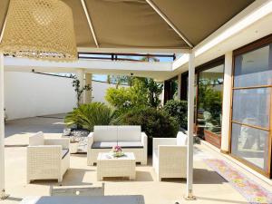 ナルドにある2 bedrooms apartement with shared pool enclosed garden and wifi at Nardo 5 km away from the beachのパティオ(白い籐の椅子、テーブル付)