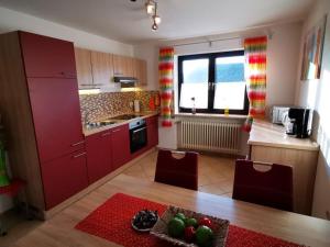 a kitchen with red cabinets and a table and chairs at Ferien bei Fuchs in Stein an der Traun