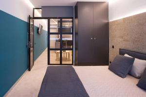1 dormitorio con 1 cama con pared azul en City Center Modern Renovated Apartment en Athens