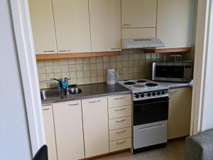 a small kitchen with a stove and a microwave at Studio at Koulukatu in Savonlinna