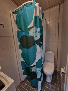 a bathroom with a toilet and a shower curtain at Studio at Koulukatu in Savonlinna