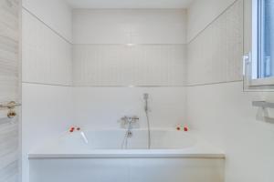 a white bathroom with a tub and a sink at Les Bambous in Sanchey +9 photos