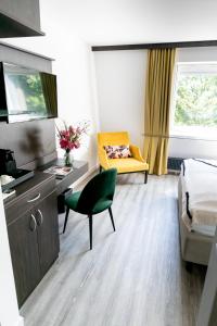 een kamer met een bed, een bank en een stoel bij Luxstay Karben - Self-Check-In in Karben