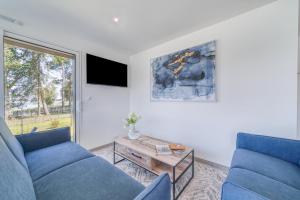 a living room with two blue couches and a table at Les Roseaux in Sanchey