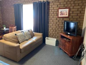 a living room with a couch and a television at Airport Whyalla Motel in Whyalla