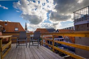 een balkon met 2 stoelen en een tafel op een dak bij Anna van Chiel in Vlissingen