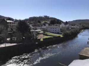 - une vue sur une rivière avec des maisons et une ville dans l'établissement Grand Studio en coeur de ville pour 2 p., à Bort-les-Orgues