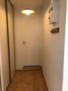 an empty hallway with a door and a light at Grand Studio en coeur de ville pour 2 p. in Bort-les-Orgues