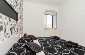 a bedroom with a black and white bed with pillows at Apartments Vanessa in Dubrovnik