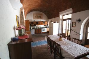 een keuken en eetkamer met een tafel en een koelkast bij Podere Campo alle Serpi in Bibbona