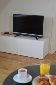 un tavolo con piatto di cibo e una TV di Forskarhotellet a Lund