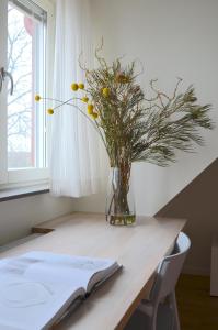 
a vase of flowers sitting on a table next to a window at Forskarhotellet Brunnshög in Lund
