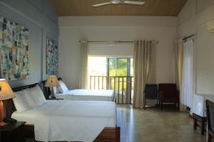 Bortianor的住宿－博約海灘度假酒店，一间带两张床的卧室和一个阳台