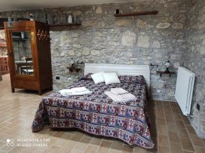 Calvi dellʼ UmbriaにあるGiardino casa Selciataのベッドと石の壁のある寝室 +36枚の写真