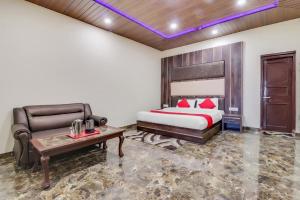 a bedroom with a bed and a couch and a table at Hotel Himdhara, Near Mall Road Dalhousie in Dalhousie