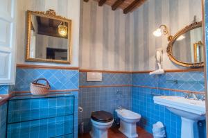 Baño de azulejos azules con aseo y lavamanos en Agriturismo I Frati en Paciano