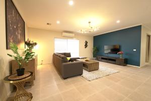 a living room with a couch and a tv at 6 Bedrooms & 4 Bathrooms Big House for Big Group in Point Cook