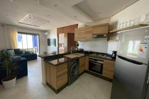 a kitchen with a refrigerator and a stove top oven at Superbe appartement en front de mer haut standing in Kenitra