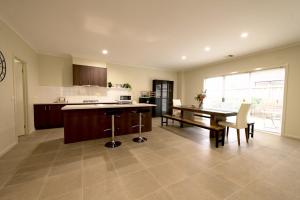 a large kitchen with a table and a dining room at 6 Bedrooms & 4 Bathrooms Big House for Big Group in Point Cook
