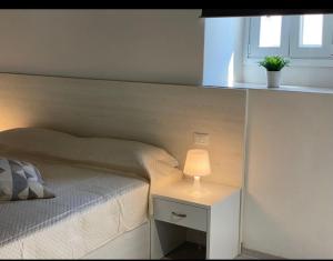 a bedroom with a bed and a table with a lamp at Villa Vittoria City in Rodi Garganico