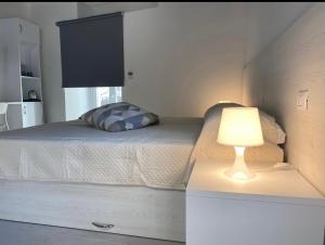 1 dormitorio con 1 cama con lámpara en un tocador en Villa Vittoria City, en Rodi Garganico