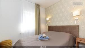 a bedroom with a bed with a blue towel on it at Villa Elena in Ventspils