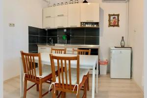 a kitchen with a table and chairs and a refrigerator at Summer app Pool spa Jacuzzi city center in Makarska