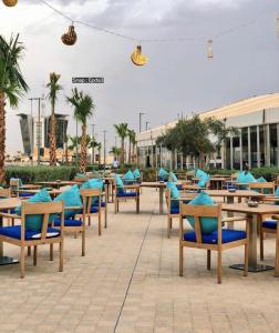 una fila de mesas y sillas con cojines azules en مقصورة مرسال سويت, en Riad
