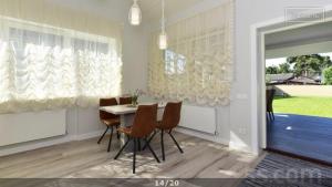 a dining room with a table and chairs and a window at Villa Elena in Ventspils +6 photos