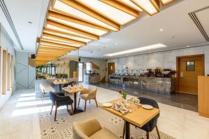 ein Restaurant mit Tischen und Stühlen und eine Küche in der Unterkunft S19 Hotel-Al Jaddaf Metro Station in Dubai