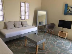Cette chambre comprend un lit, une télévision et une chaise. dans l'établissement Makares, à Donoussa
