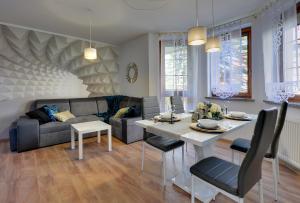 salon z kanapą i stołem w obiekcie Apartament Szmaragdowy w mieście Karpacz